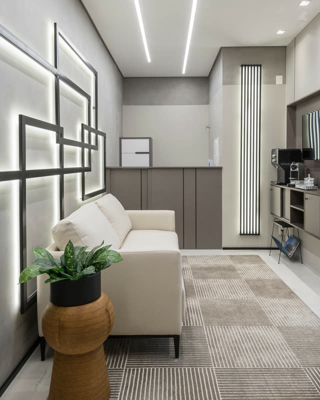 Sala de espera com iluminação linear e sofá claro